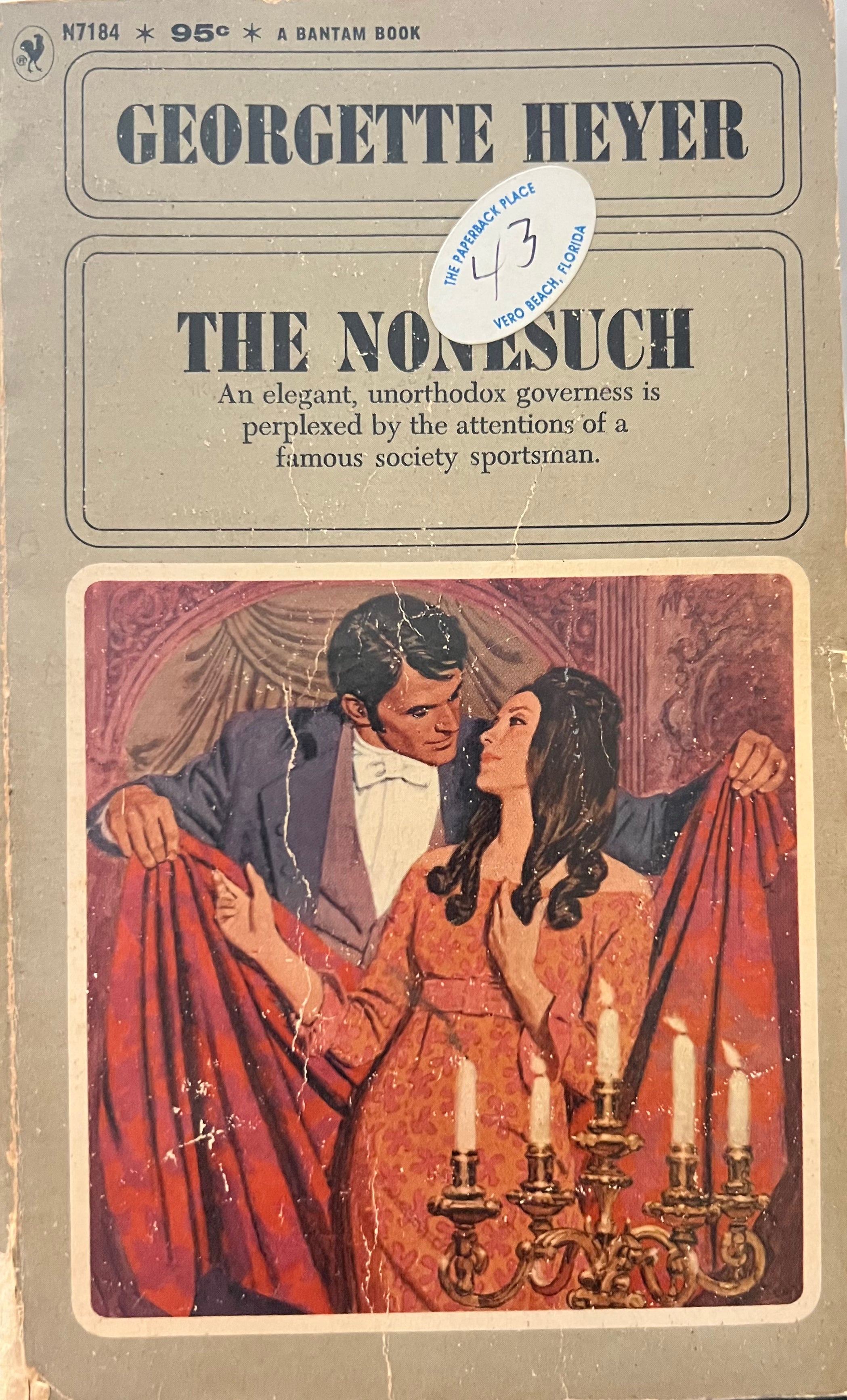 Vintage book cover of 'The Nonesuch' by Georgette Heyer with a couple embracing and candles in the background.