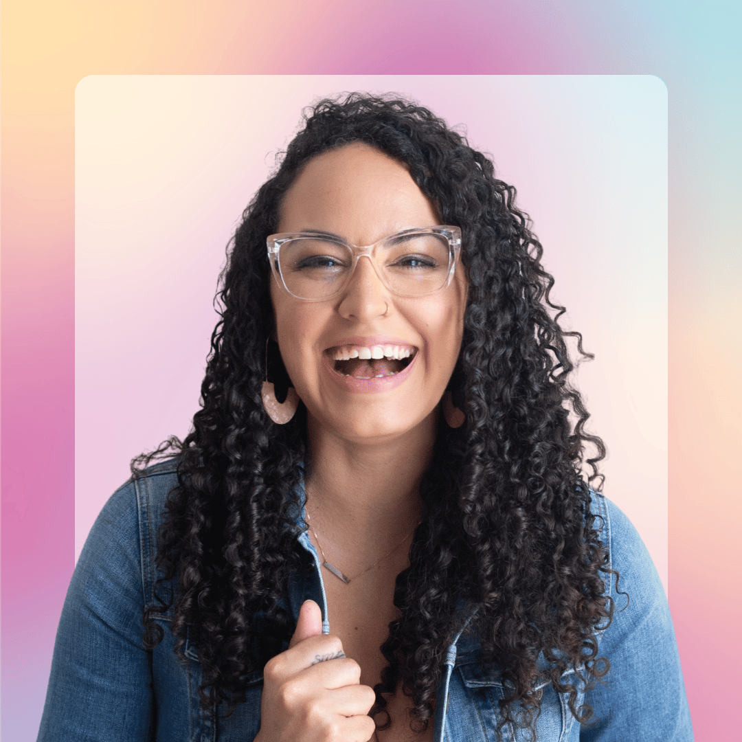 Woman with curly hair and glasses smiling against a colorful background