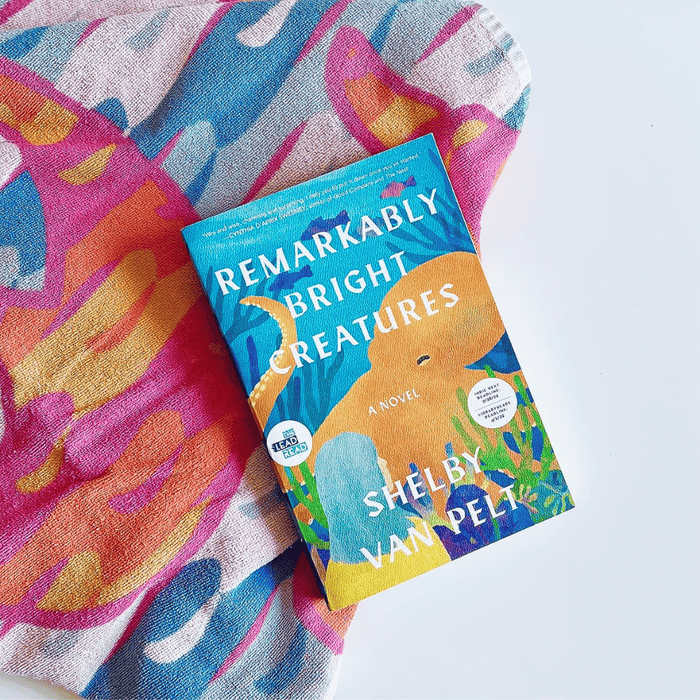 Remarkably Bright Creatures by Shelby Van Pelt book cover on colorful fabric – cozy contemporary fiction novel about friendship, grief, and an octopus