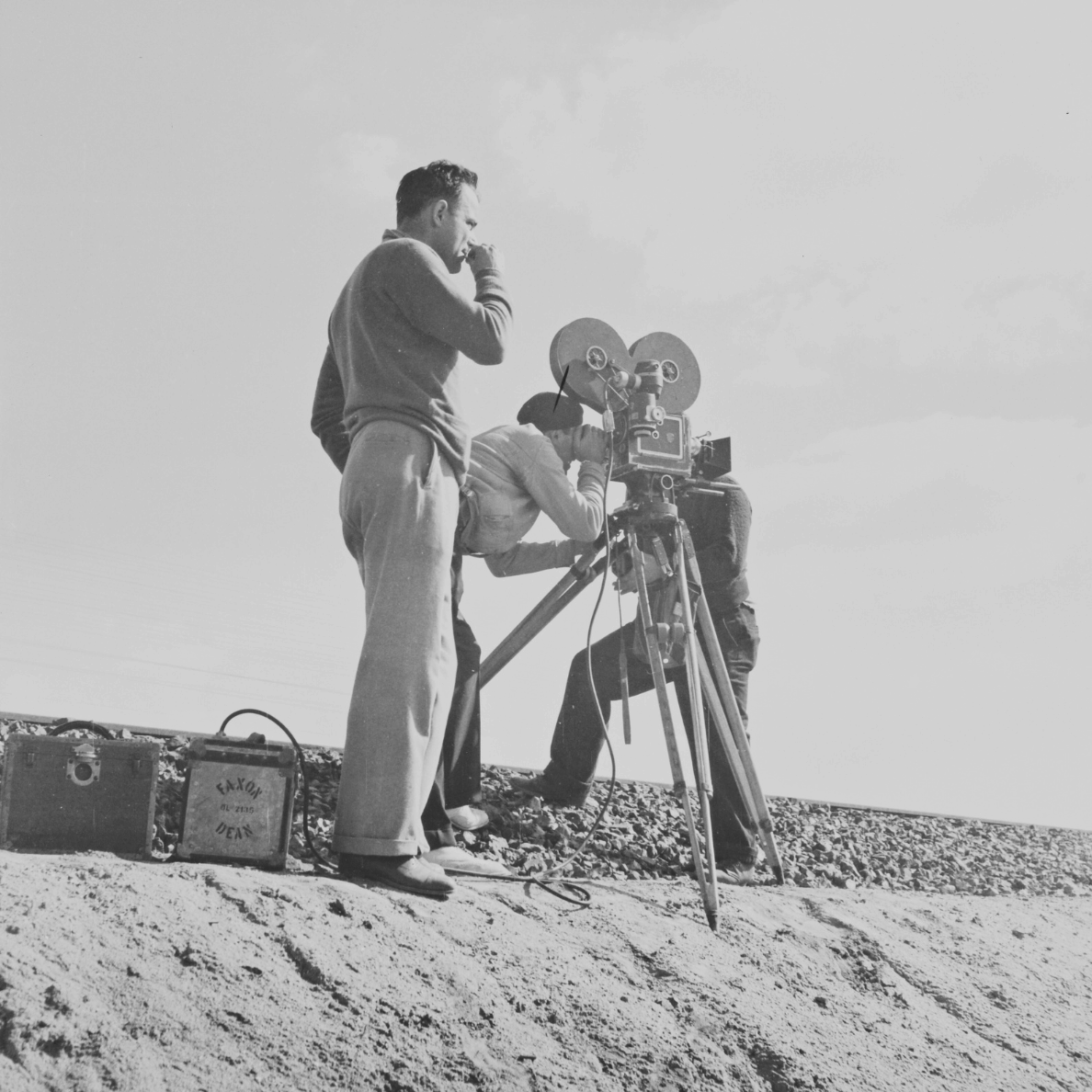 Vintage black-and-white photo of a film crew operating an old movie camera on set, representing books adapted into TV shows and movies.