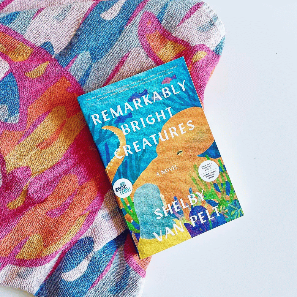 Book titled 'Remarkably Bright Creatures' by Shelby Van Pelt on a colorful fabric background