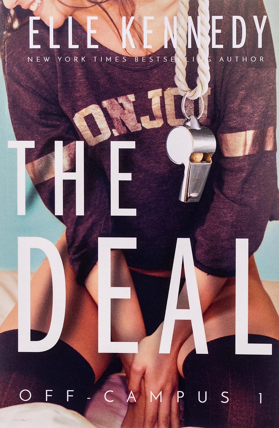 Book cover of 'The Deal' by Elle Kennedy featuring a person in a sports jersey with a whistle.